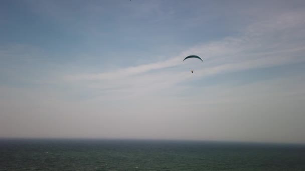 einige Gleitschirmflieger fliegen an der Steilküste der Ostsee entlang