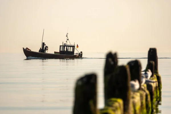 Un bateau de pêche sort à la mer tôt le matin lorsque la mer — Photo