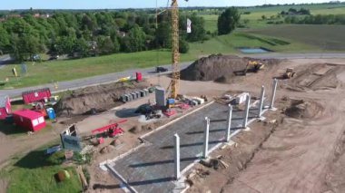 Bir insansız hava aracı, büyük bir üretim salonunun inşa edildiği büyük bir şantiyenin üzerinden uçuyor.. 