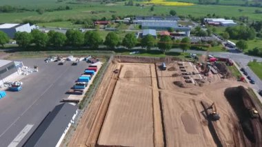 Bir insansız hava aracı, büyük bir üretim salonunun inşa edildiği büyük bir şantiyenin üzerinden uçuyor.. 