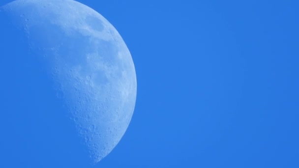 三日月が雲一つない青い午後の空に沿って動いている — ストック動画
