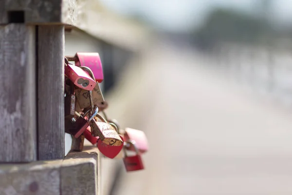 Cadeados gravados pendurados em uma ponte como um símbolo para os amantes — Fotografia de Stock