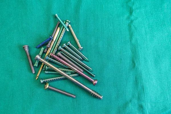Verschillende chirurgische Titanium schroeven liggen verspreid op een groene surgi — Stockfoto