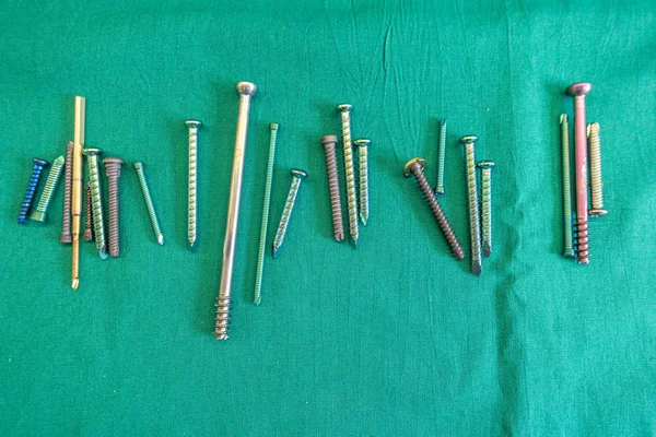 çeşitli cerrahi titanyum vidalar yeşil bir surgi yayılmış yalan