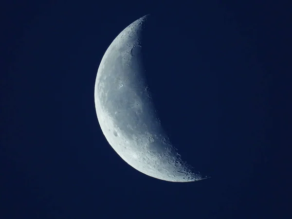 W niebieskim rankiem niebo stoi zanikający ćwierć księżyca — Zdjęcie stockowe