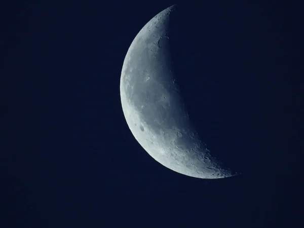 W niebieskim rankiem niebo stoi zanikający ćwierć księżyca — Zdjęcie stockowe
