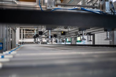 bir fabrika salonunda donanımlı dev bir makine var 