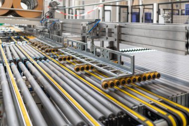 bir fabrika salonunda silindirler kullanan dev bir makine var 