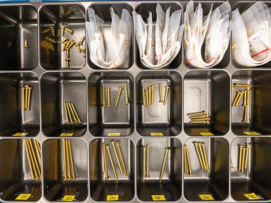 bir tepside, titanyum cerrahi vidalar boyutuna göre sıralanır