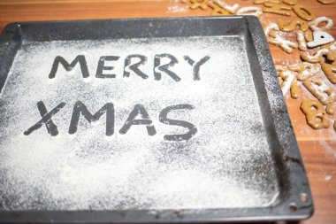 Kelimeler Merry Xmas serpilir bir fırın tepsisine yazılır 