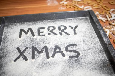 Kelimeler Merry Xmas serpilir bir fırın tepsisine yazılır 