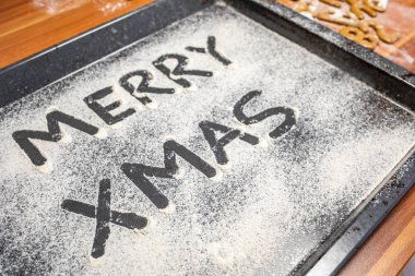 Kelimeler Merry Xmas serpilir bir fırın tepsisine yazılır 