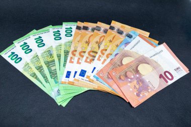 karanlık bir masada yayılan bir sürü avro banknotu