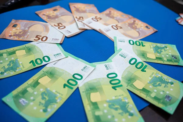 Veel eurobankbiljetten liggen verspreid op een blauwe basis — Stockfoto