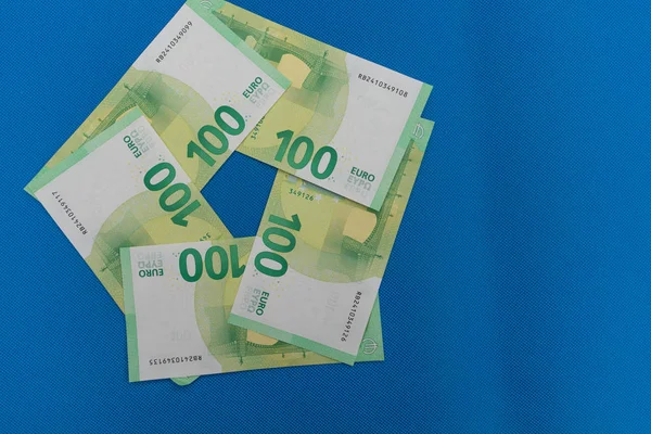 Veel eurobankbiljetten liggen verspreid op een blauwe basis — Stockfoto