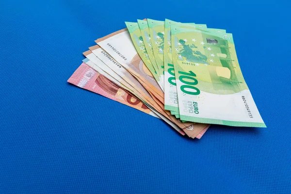Molte banconote in euro sono distribuite su base blu — Foto Stock