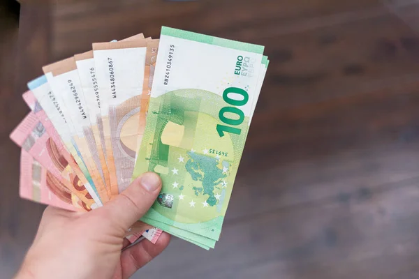 Una mano detiene un gran numero di banconote in euro spread — Foto Stock