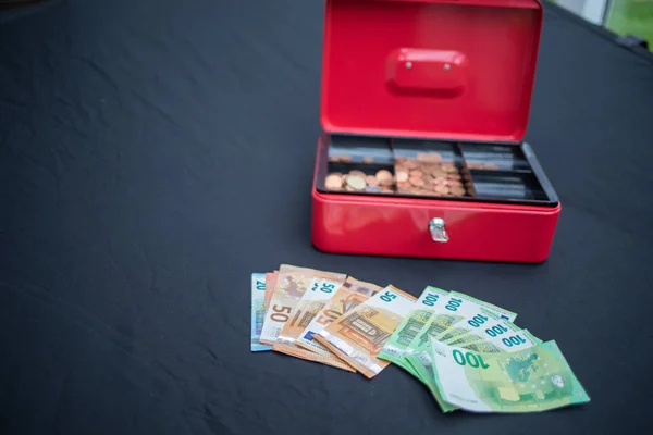 Багато банкнот євро розкидані навпроти червоного готівкового бою — стокове фото