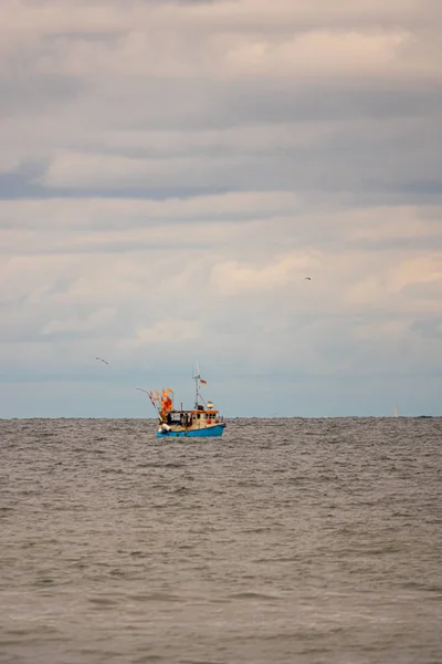 Longe no mar flutua um barco de pesca, que é cercado pelo homem — Fotografia de Stock