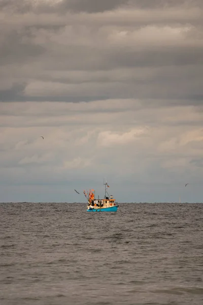 Longe no mar flutua um barco de pesca, que é cercado pelo homem — Fotografia de Stock
