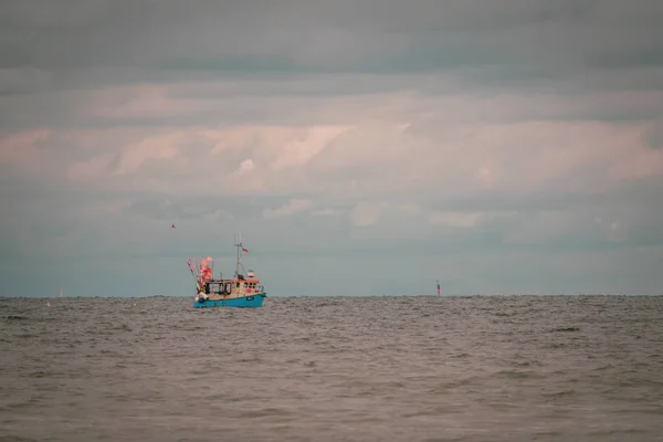 Longe no mar flutua um barco de pesca, que é cercado pelo homem — Fotografia de Stock