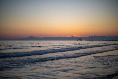 Sahilde dalgalar ve arka planda.