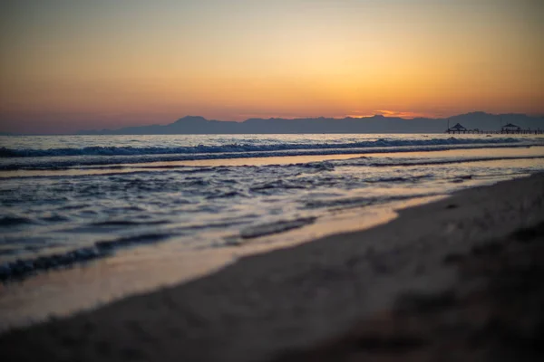 En una playa en primer plano están las olas y en el fondo — Foto de Stock