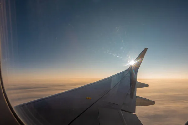 De rechtervleugel van het vliegtuig stijgt op in de blauwe lucht — Stockfoto