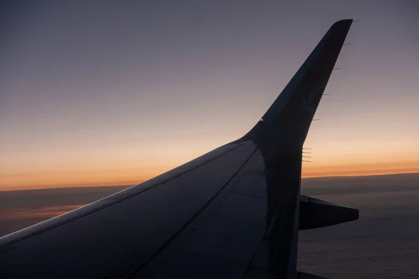 De rechtervleugel van het vliegtuig stijgt op in de blauwe lucht — Stockfoto