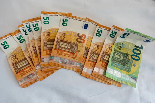 Veel eurobankbiljetten liggen verspreid op een bed met een wit dekbed c — Stockfoto