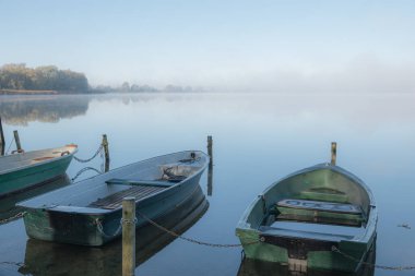 Gölde bazı kayıklar demirli ve gölde sis var. 