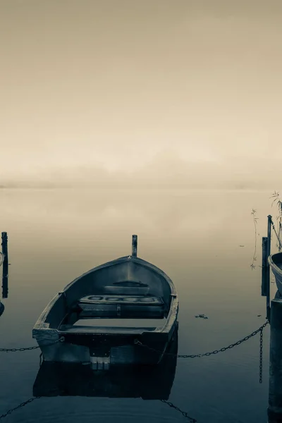 Auf einem See liegen einige Ruderboote fest und auf dem See liegt Nebel — Stockfoto