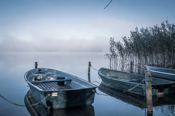 Em um lago alguns barcos a remos ancoram-se e no lago há nevoeiro — Fotografia de Stock