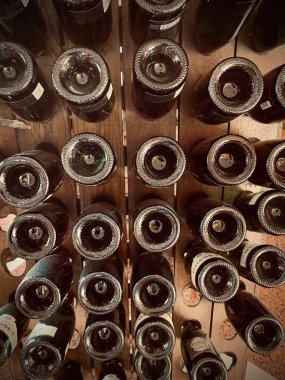 Şampanya şişeleri ahşap rafta baş aşağı duruyor.
