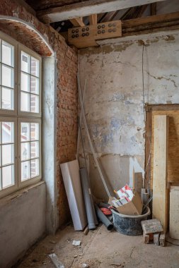 Eski bir inşaat sahasının köşesinde çeşitli borular ve tahtalar var.