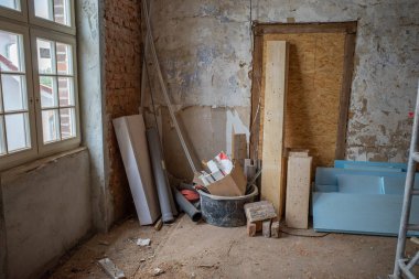 Eski bir inşaat sahasının köşesinde çeşitli borular ve tahtalar var.