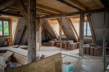 Bir binanın üst katında çatı kiremitleri var. Çatı kaplamaya hazır.