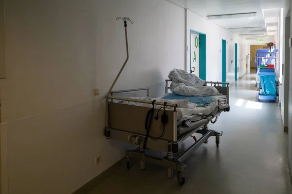 there\'s an empty patient bed in a surgical hallway