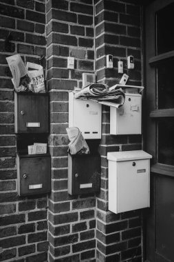 six overcrowded mailboxes are hanging in a doorway