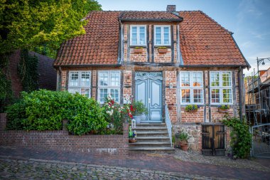 Eski bir caddede eski bir yarı keresteli ev duruyor. 