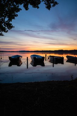 Gün batımında gölde yan yana uzanan kayıklar.