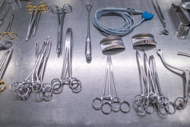 Sterilizasyon bölümünde birçok temizlenmiş enstrüman metal bir masanın üzerinde yatıyor.