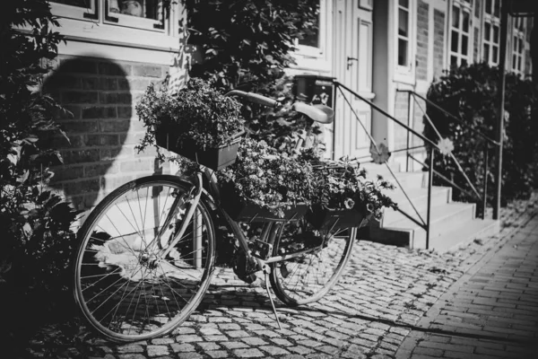 在一座半木结构的老房子前面 立着一辆种有鲜花供装饰的自行车 — 图库照片