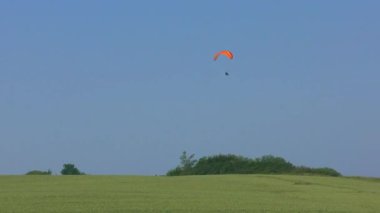Bazı paraşütçüler güzel havada ve mavi gökyüzünde uçurumlarda uçar.