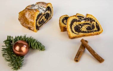 Beyaz bir üste haşhaş tohumu pastası ve noel süsü var.