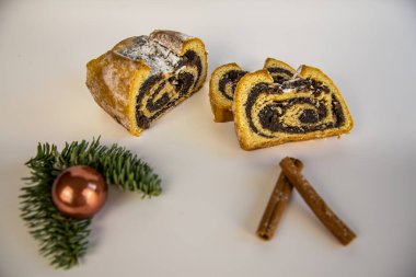 Beyaz bir üste haşhaş tohumu pastası ve noel süsü var.
