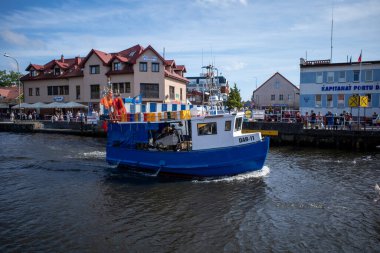 Polonya 'nın Kolberg limanındaki açık bir köprüden geçen bir balıkçı teknesi.