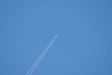 Bir yolcu uçağı gökyüzünde yükseklere uçar ve bir iz bırakır.