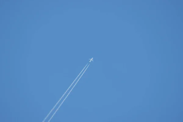 Ένα Επιβατικό Αεροπλάνο Πετά Ψηλά Στον Ουρανό Και Σχηματίζει Ένα — Φωτογραφία Αρχείου