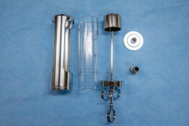 Parçalanmış ürolojik bir idrar kesesi şırıngası mavi bir işletim merkezinde yatıyor.